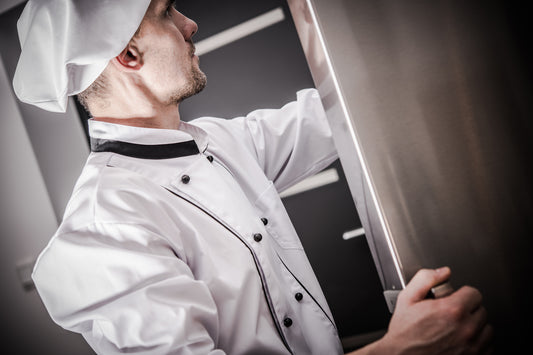A chef opening a refrigerator